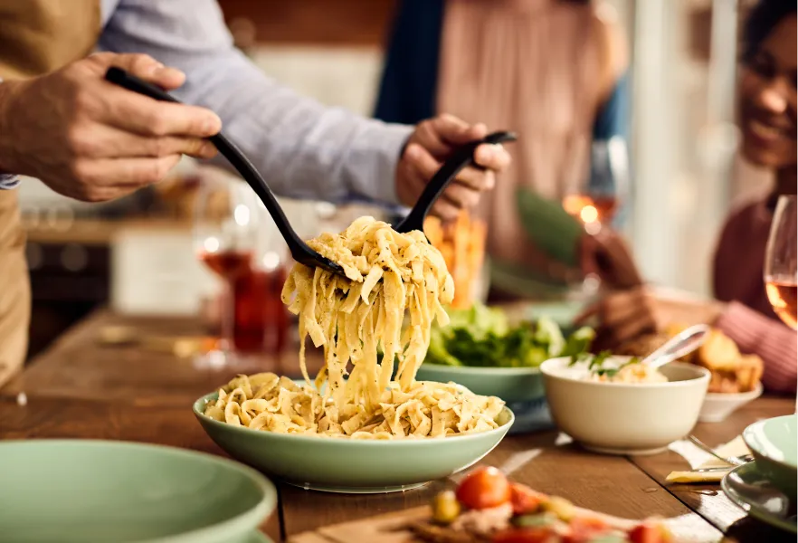 Un plato de pasta se mezcla sobre una mesa bien servida