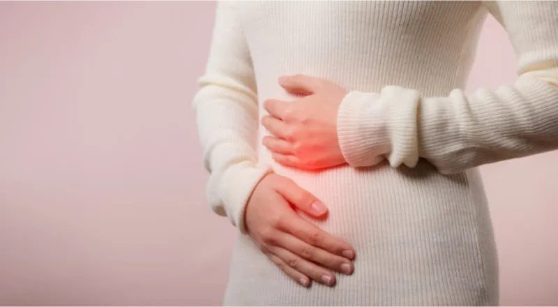 mujer que se lleva las manos al estómago por una indigestión