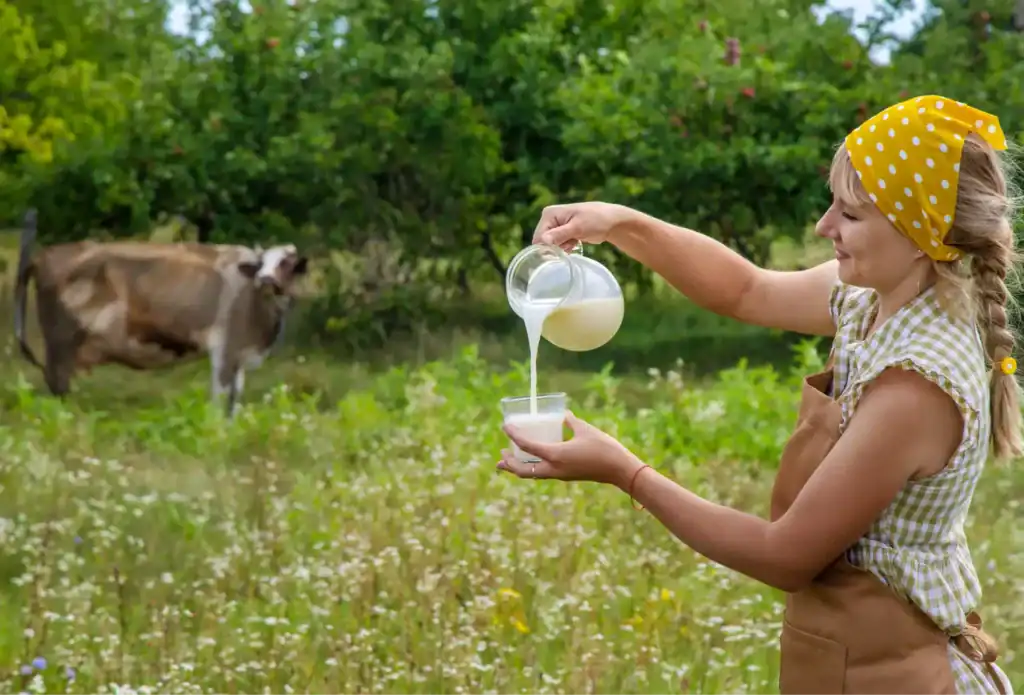 Mujer sirviendo leche fresca en el campo