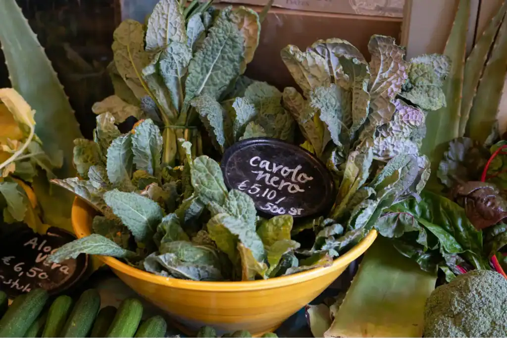 Col negra fresca (kale) en un bol de mercado, verdura de hoja verde recomendada en recetas contra el estreñimiento